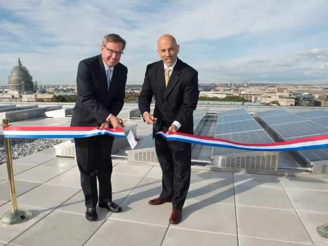 Two people at a ribbon cutting ceremony.
