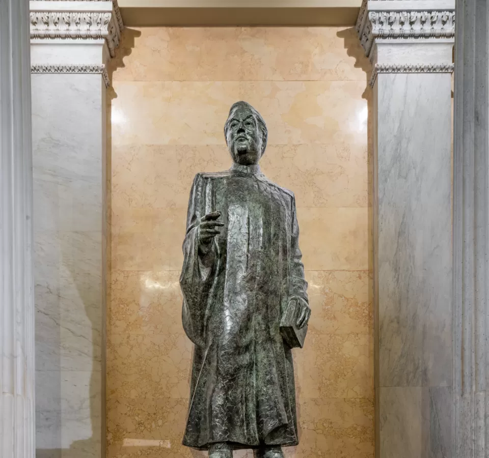 Bronze statue of a person standing.