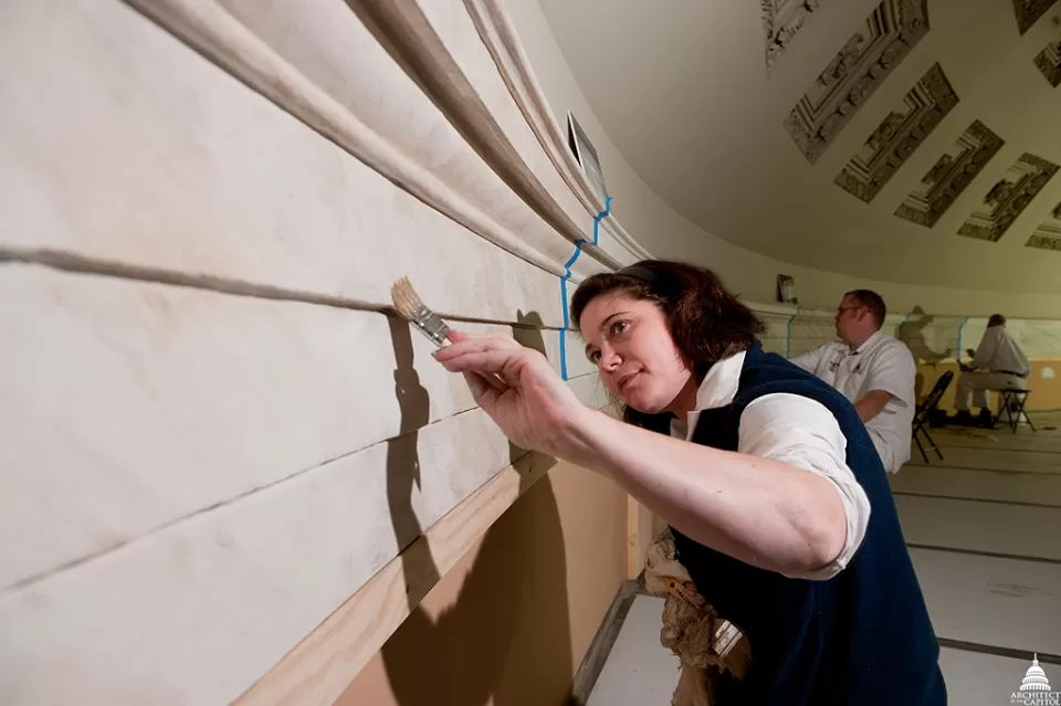 Claire Sharp, AOC Capitol decorative painter, helps restore the Old Senate Chamber using a faux marbleizing technique.