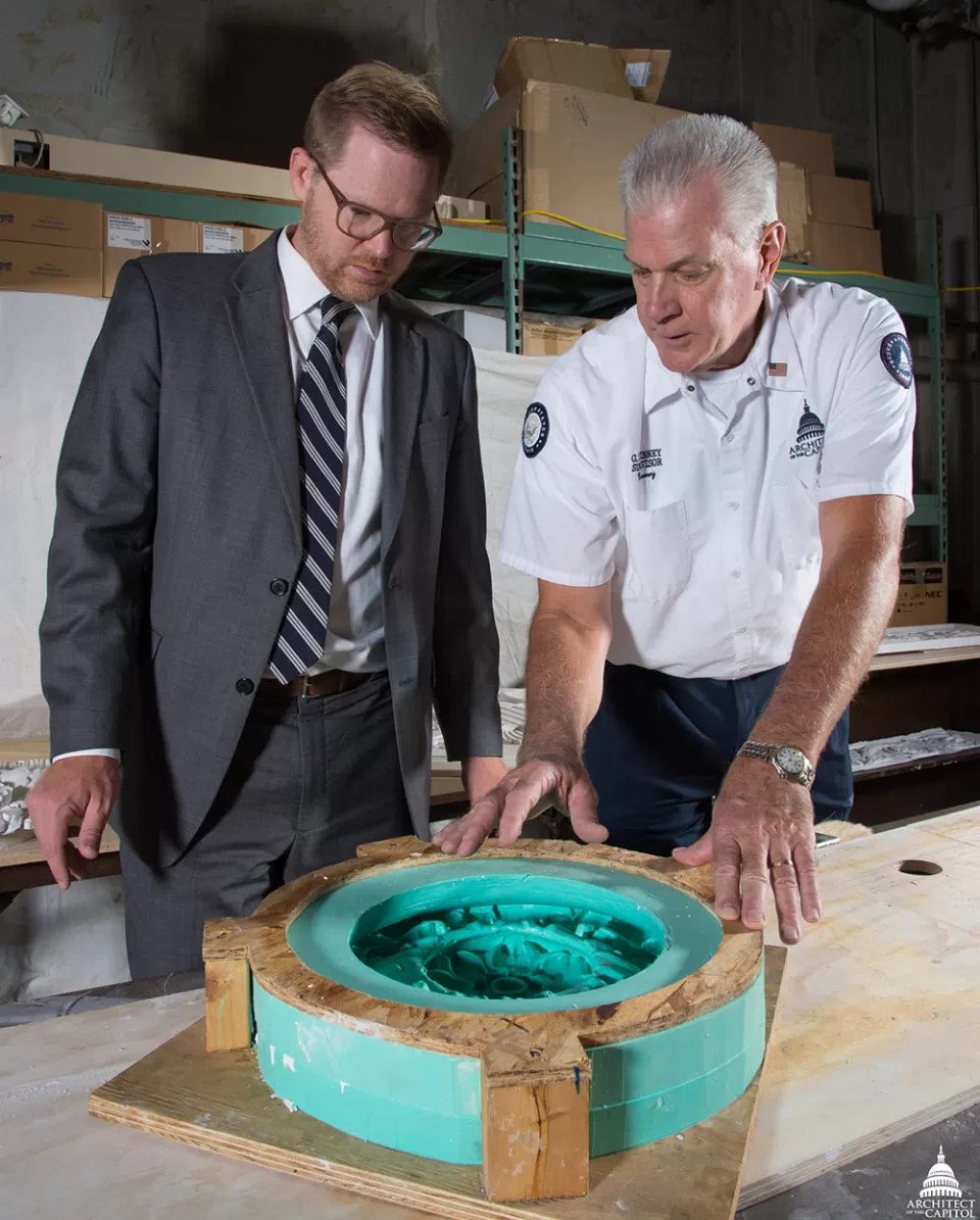 Assistant Superintendent for Tenant Services Paul Kirkpatrick learns more about the mold making process from Senate Masonry Branch Supervisor Glenn DeVinney, who has been with the Architect of the Capitol for 20 years.