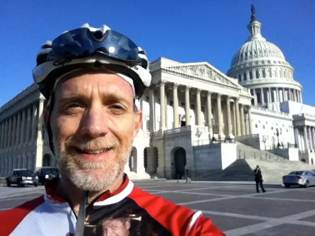 Person wearing a bike helmet in front of the U.S. Capitol.