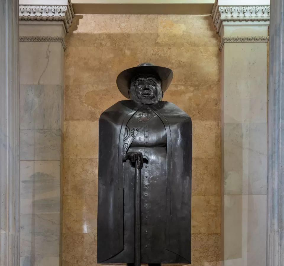 Bronze statue of a person standing.