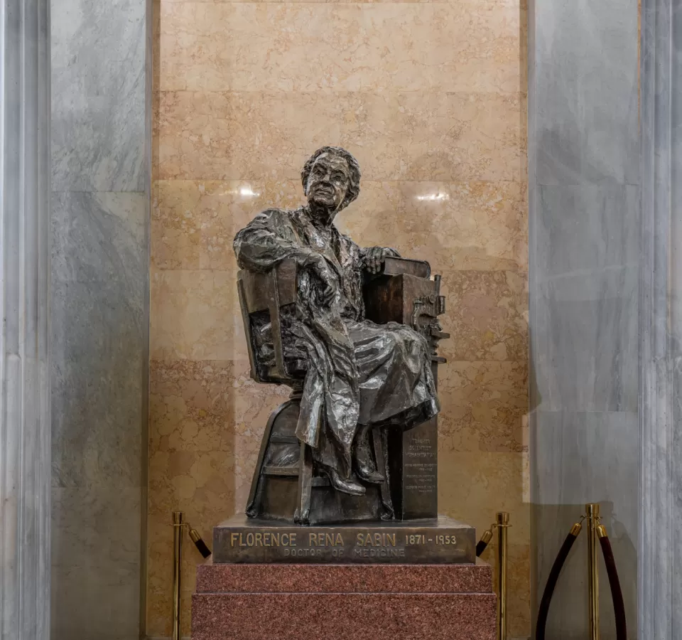 Bronze statue of a person sitting.