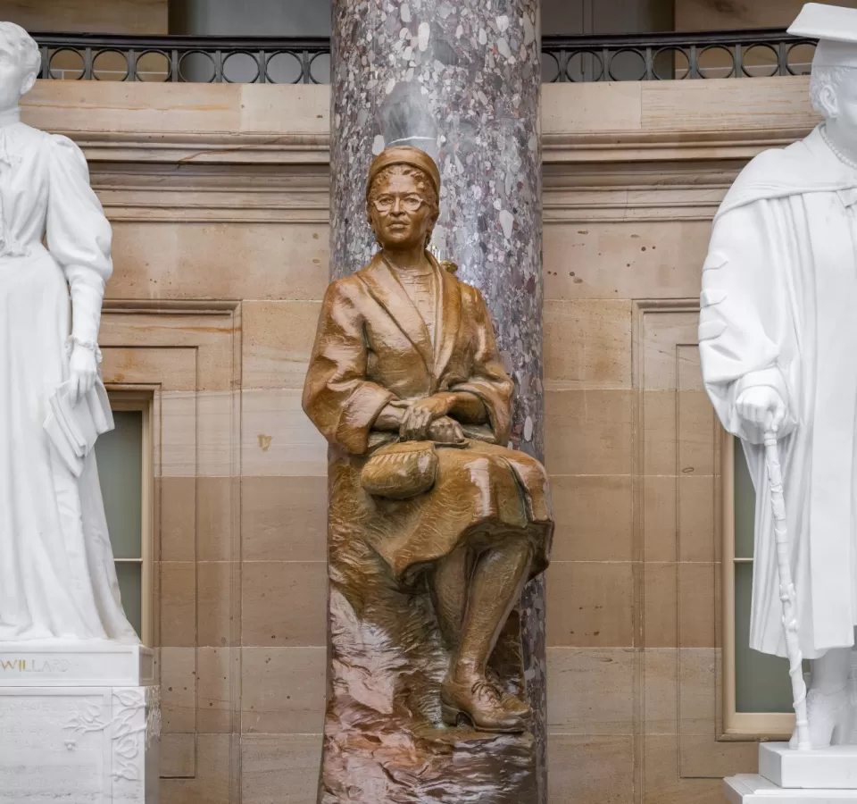 Bronze statue of a person sitting.