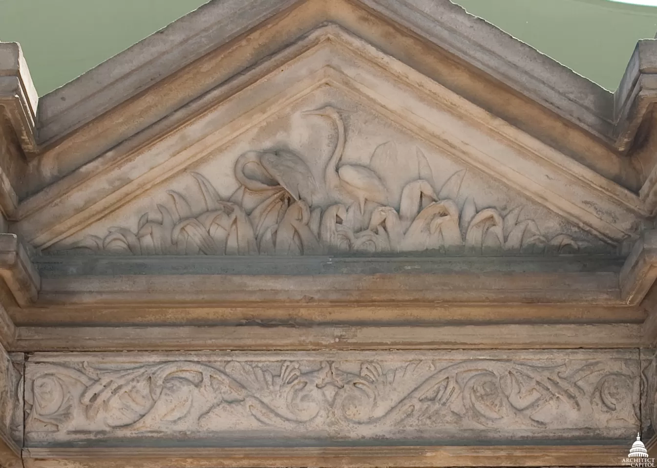 Blue heron carved in stone at the focal point, the central fountain, in the perimeter wall surrounding Capitol Square.