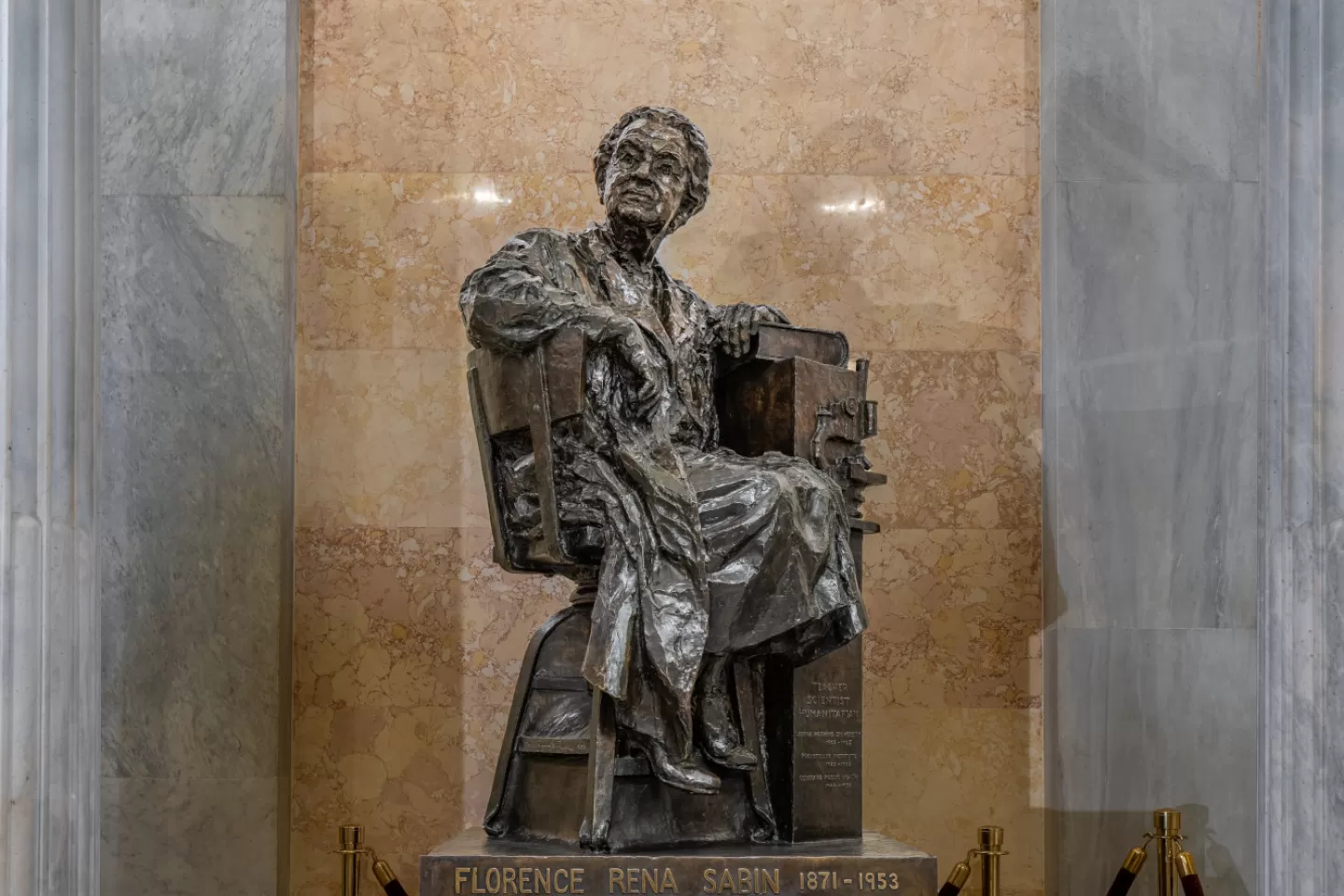 Bronze statue of a person sitting.