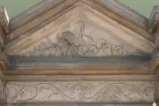 Blue heron carved in stone at the focal point, the central fountain, in the perimeter wall surrounding Capitol Square.