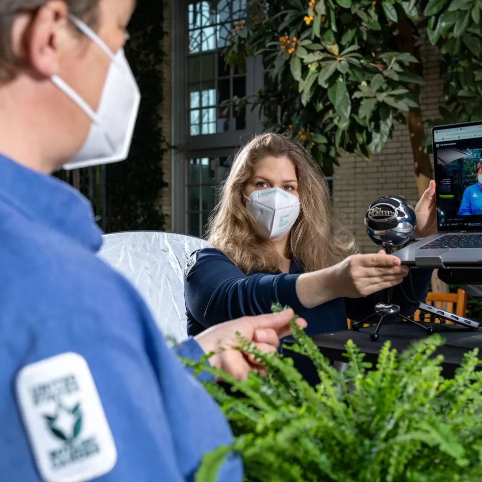 Grace Anderson adjusts the camera and laptop for an online horticultural education program.