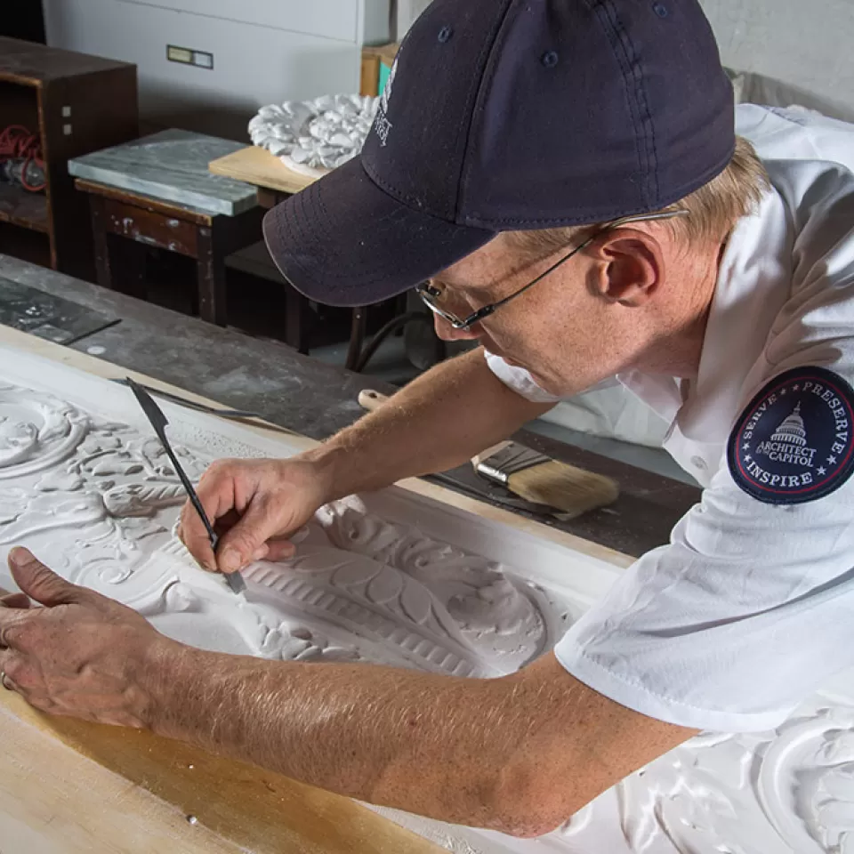 Robert Gannon smoothes out imperfections in a plaster cast.