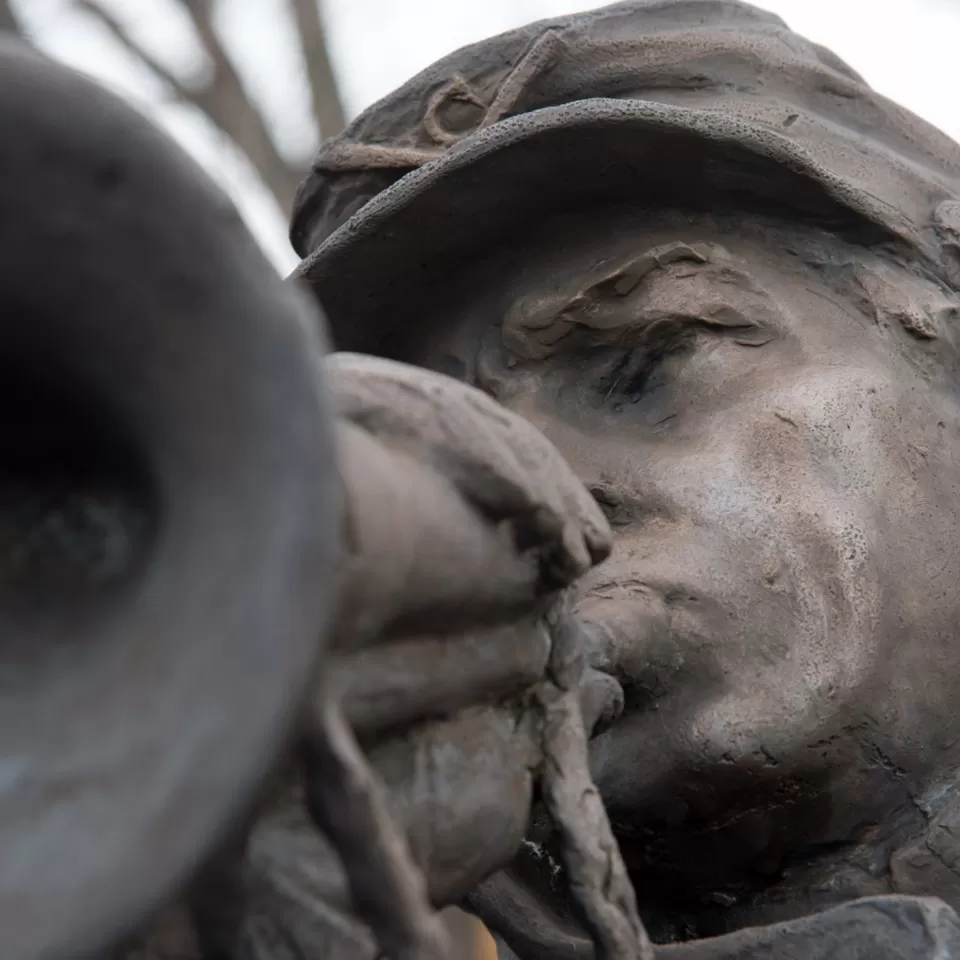 Sculpture detail of a person playing an instrument.
