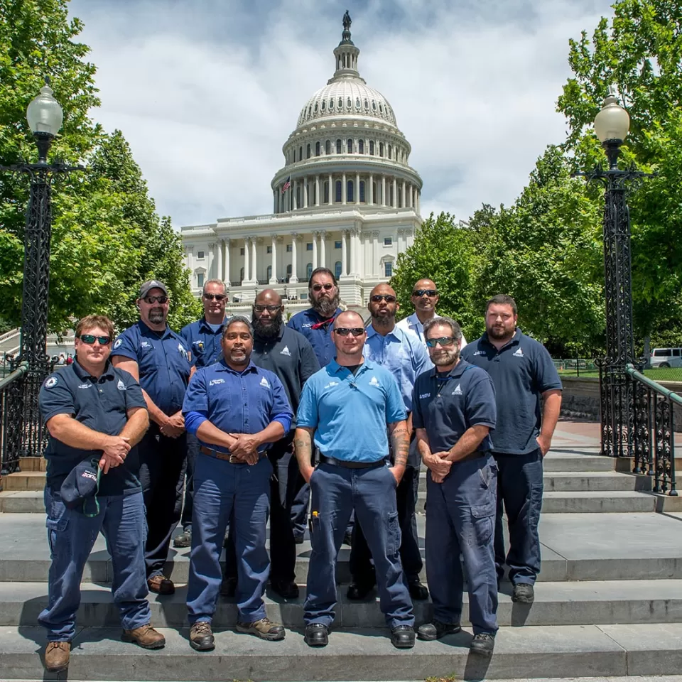 Group photo of the Architect of the Capitol high-voltage electricians on the West Front of the U.S. Capitol.