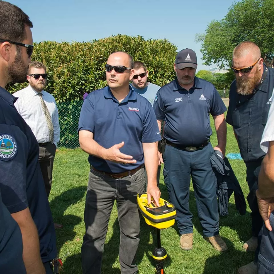 AOC employees test an underground utility locator on the West Front lawn of the U.S. Capitol.