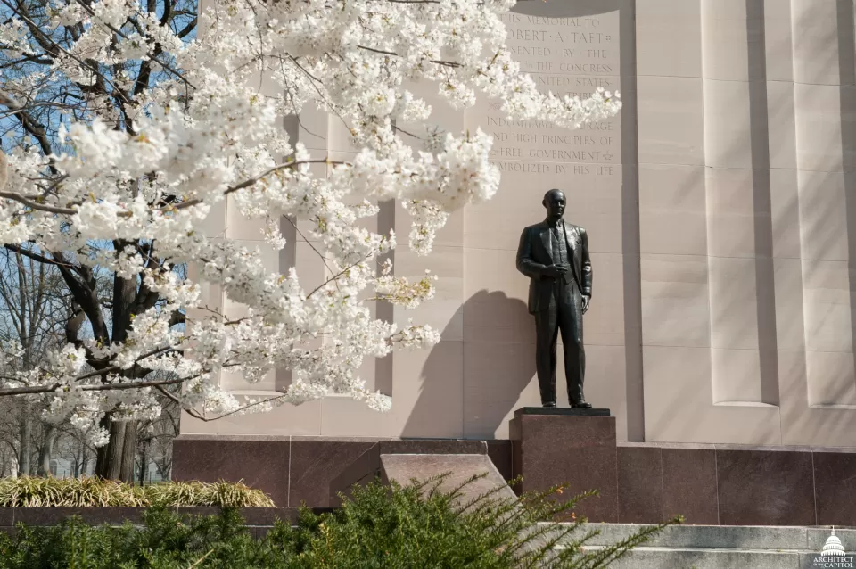 A statue next to tree blossoms.