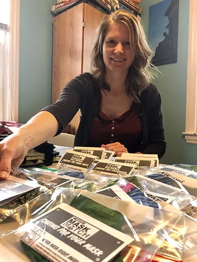 CVC employee putting together packages of sewn masks and sewing materials.