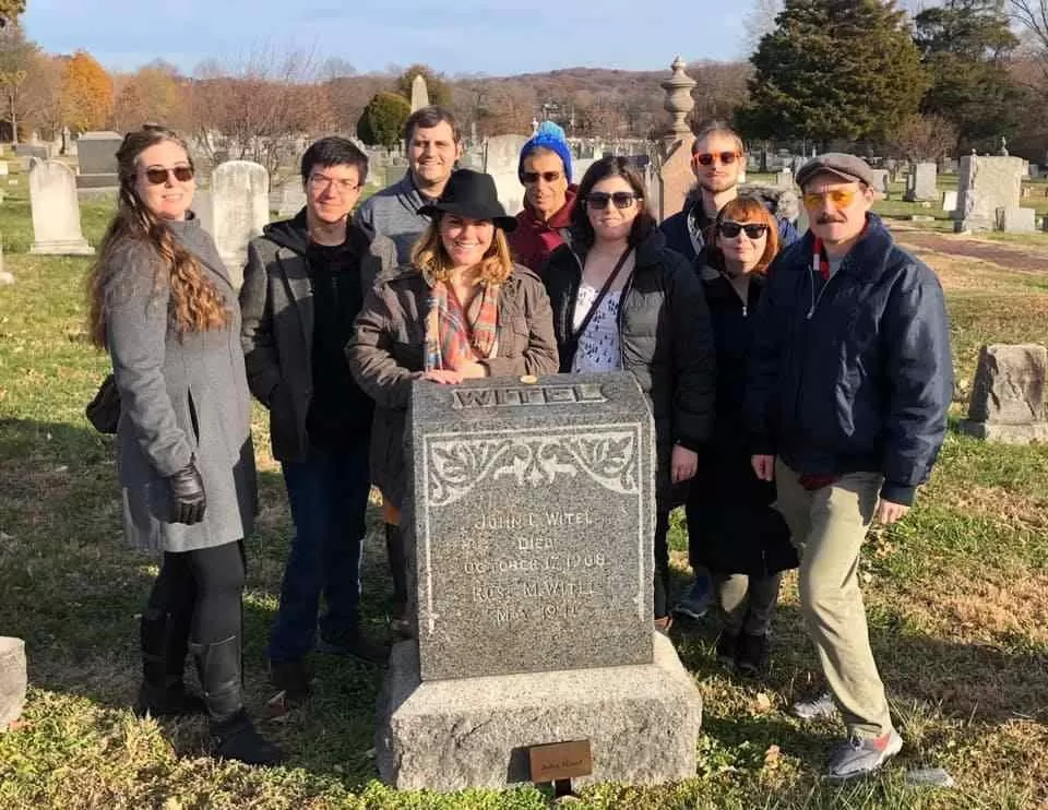 Guides Lauren Shiflet, Scott Jung, Nicholas Oristian, Laurel Martin, Joe Wasiak, Carrie Gallagher, Blake Lindsey, Janet Clemens and Dan Pearson at the grave of John Witel. The group placed markers at the graves of the Capitol guides.