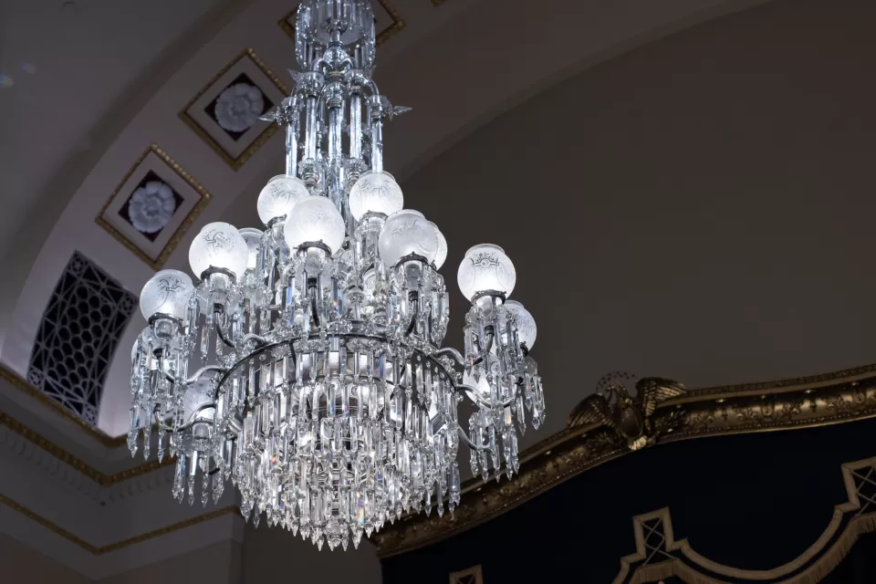 White brass with crystal prisms and blown glass can be seen hanging from the Homeland Security hearing room.