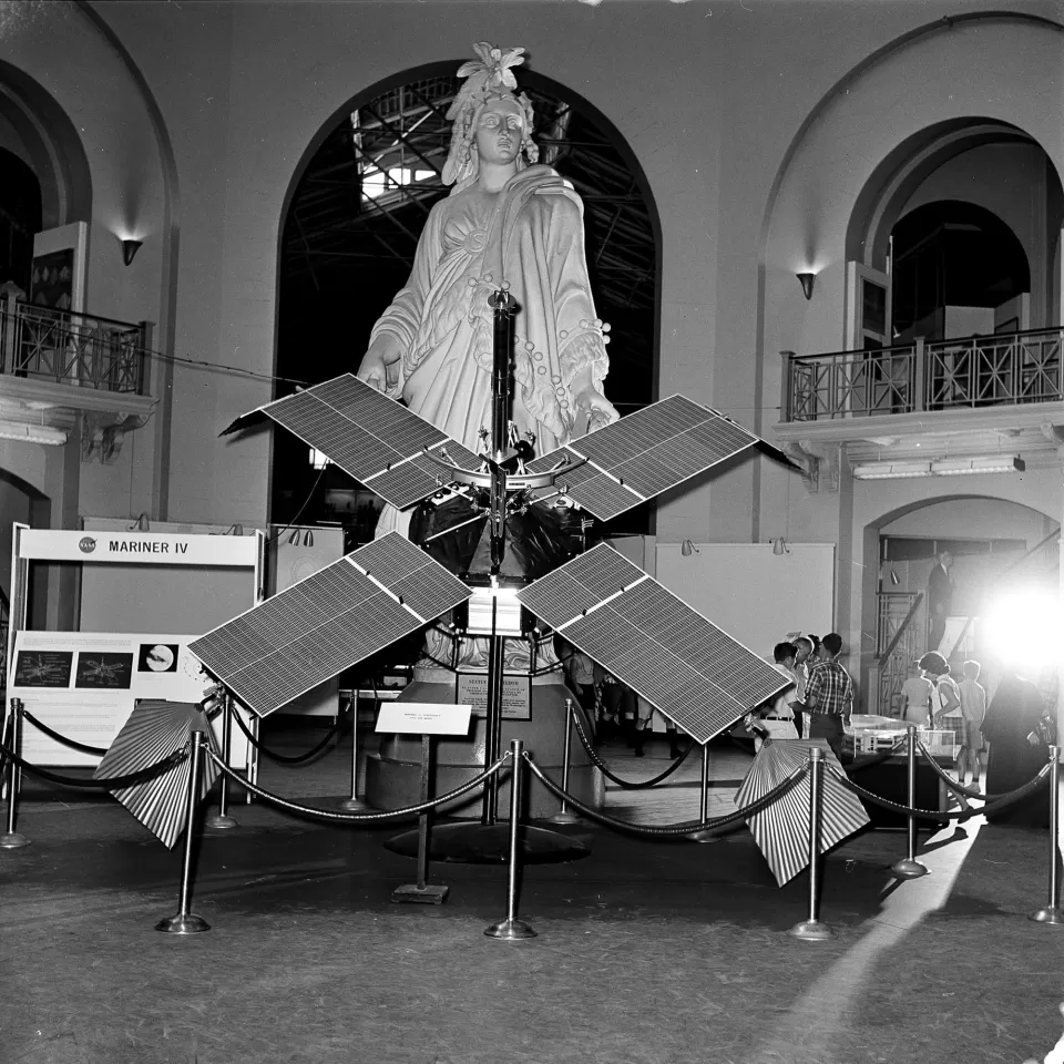 Plaster statue behind a spacecraft.
