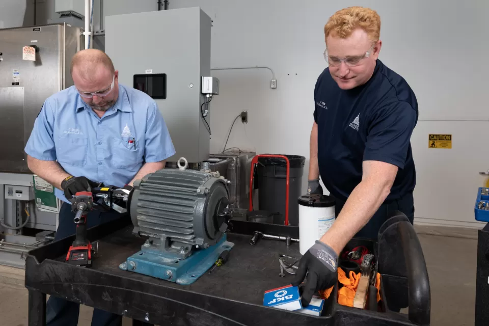 Two people working on equipment.