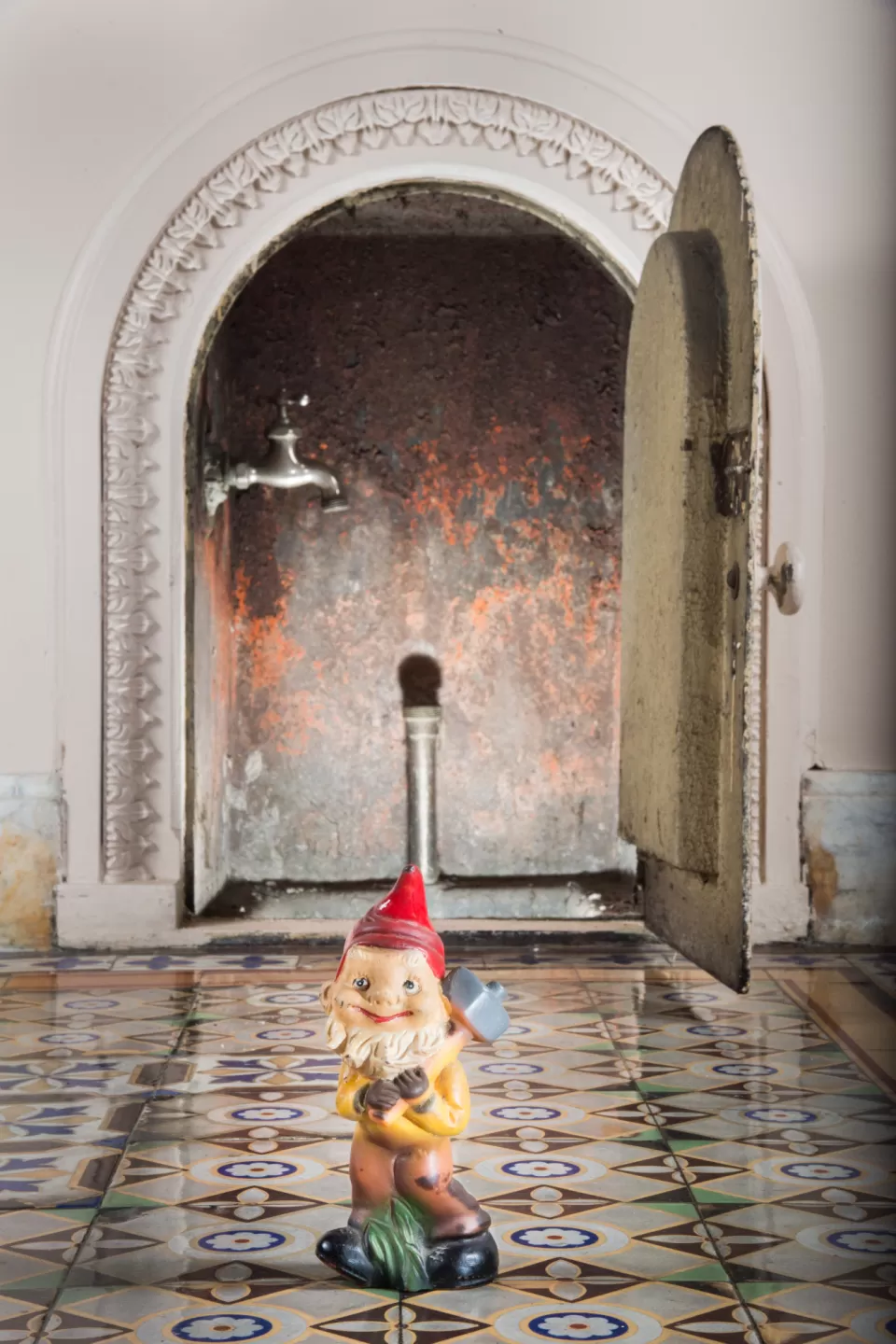 Garden gnome in front of a doorway.