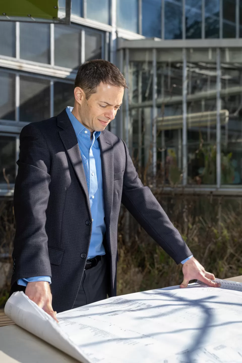 Person standing looking down at paper on a table.