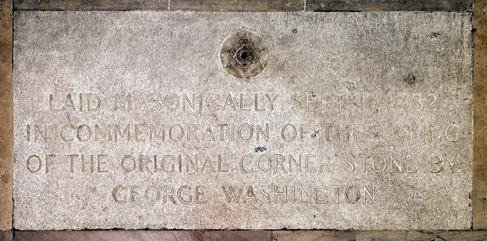 The marker reads: "LAID MASONICALLY SEPT 17, 1932 IN COMMEMORATION OF THE LAYING IF THE ORIGINAL CORNERSTONE BY GEORGE WASHINGTON."