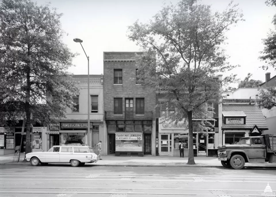 A view of the block where the Madison Building now stands. Children would watch inauguration parade preparations from the iron balcony above the cobbler shop in the tallest building pictured.