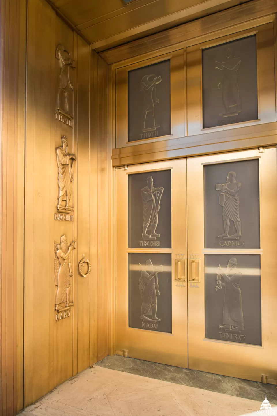 The bronze and glass doors of the John Adams Building.