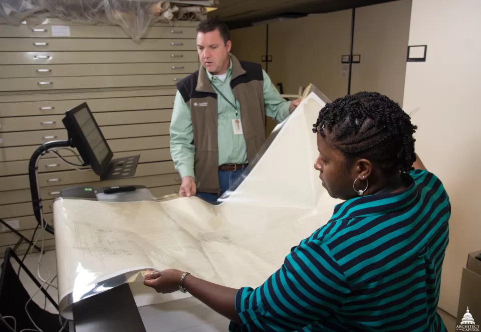 Jim Corbus and Jocelyn Travers, Records Management and Archives Branch, preserve historic architectural drawings.