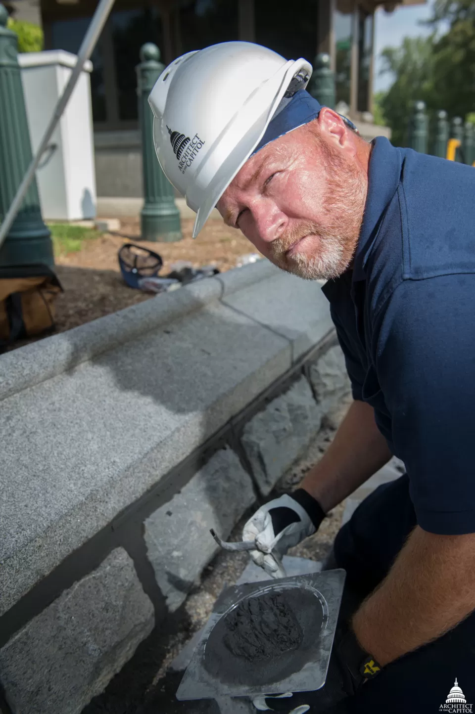 Russell Jones of the AOC Construction Division demonstrates a cool tool for applying grout to the Olmsted wall.