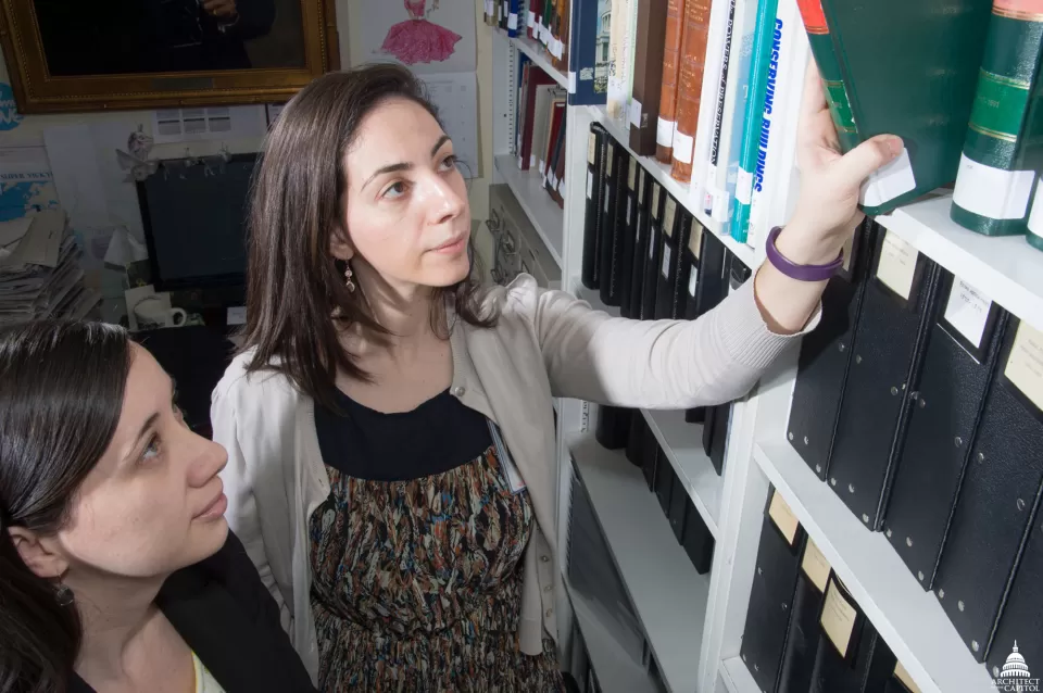 AOC's Erin Nelson (left) and Vicky Villano search the Architect's Annual Reports for clues to the location of the U.S. Capitol's first elevator.