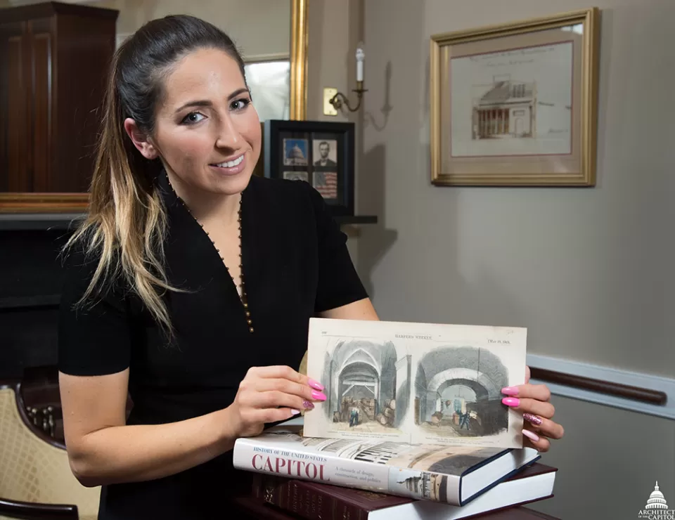 Capitol Building Executive Assistant Gabriella Marvin holds a newspaper clipping that shows what her U.S. Capitol office looked like during the Civil War.
