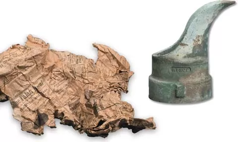 Newspaper and bronze spout found during the Cannon Renewal project.