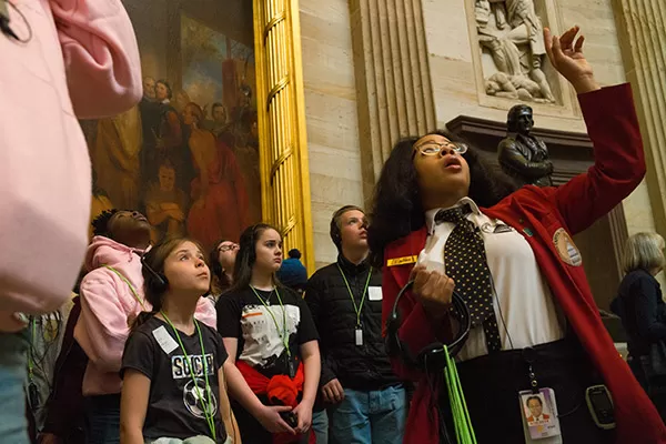 A visitor guide shows a tour group through the U.S. Capitol Rotunda.
