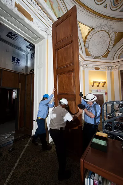 Carefully removing a 120-year-old historic door at the Thomas Jefferson Building, weighing upwards of 275 pounds.