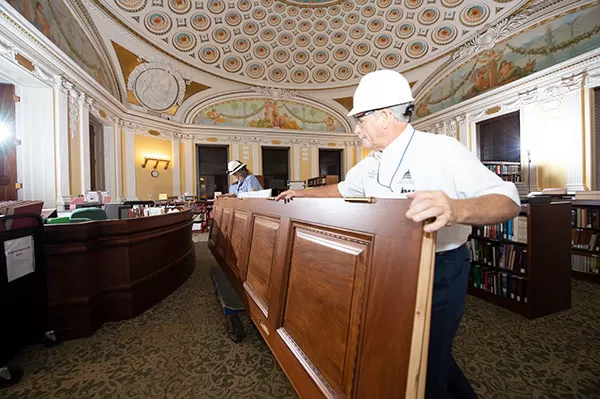 Maneuvering a door through occupied space on its way to being reinstalled in the Thomas Jefferson Building.