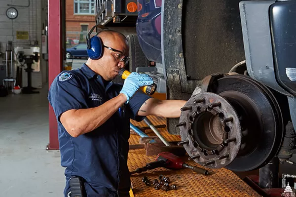 A member of Capitol Grounds and Arboretum inspects an AOC vehicle operating on the Capitol campus.