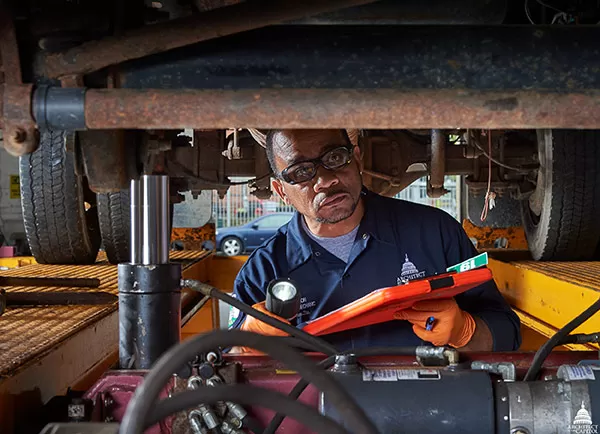 Carefully checking the undercarriage of an AOC vehicle.