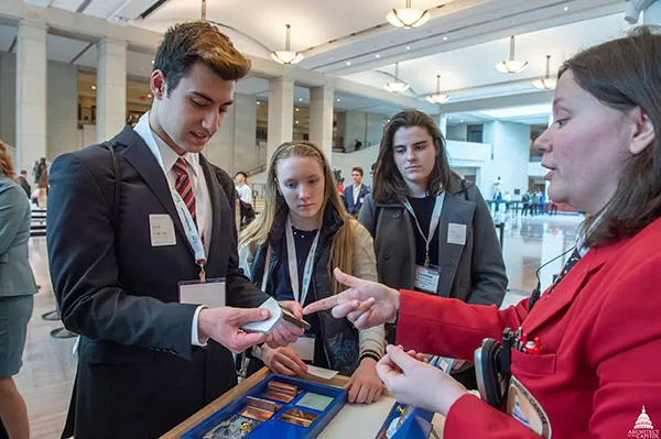 Visitor Guide Dr. Alyssa Warrick uses the Capitol Materials Cart to interact with visitors in Emancipation Hall.
