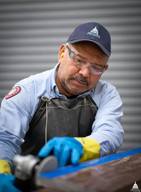AOC Capitol Building Mason Shop employee polishes a section of marble. 