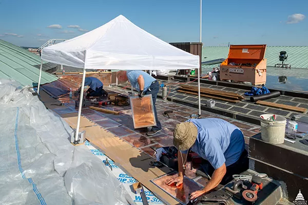 Members of the AOC Sheet Metal Shop install flat seam copper roof panels.