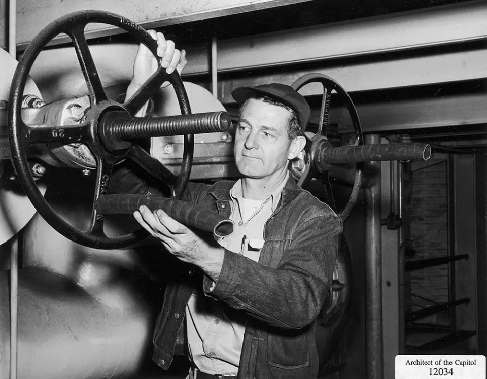 A worker inspects a valve in the Capitol Power Plant, which turns 100 years old this year.