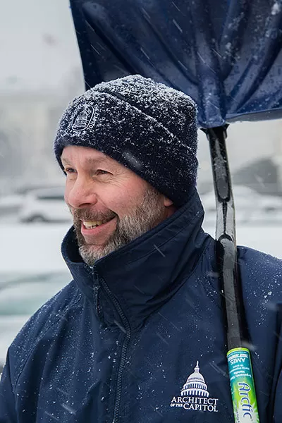 A member of the Architect of the Capitol team removed snow with a smile.
