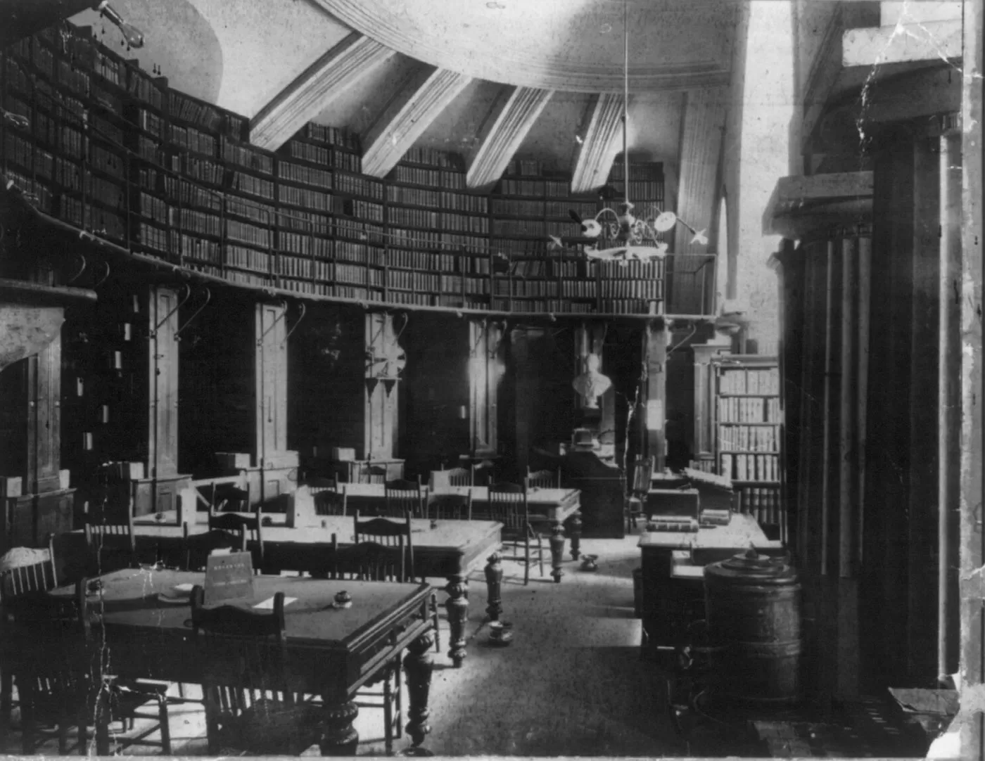 Desks with chairs and shelves with books.