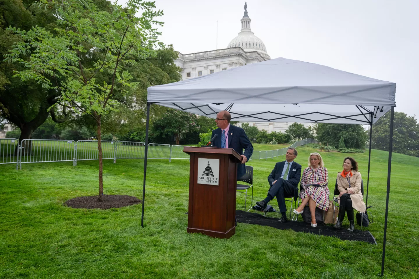 People sitting under a tent.