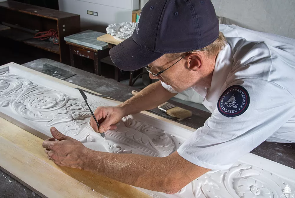 Robert Gannon smoothes out imperfections in a plaster cast.