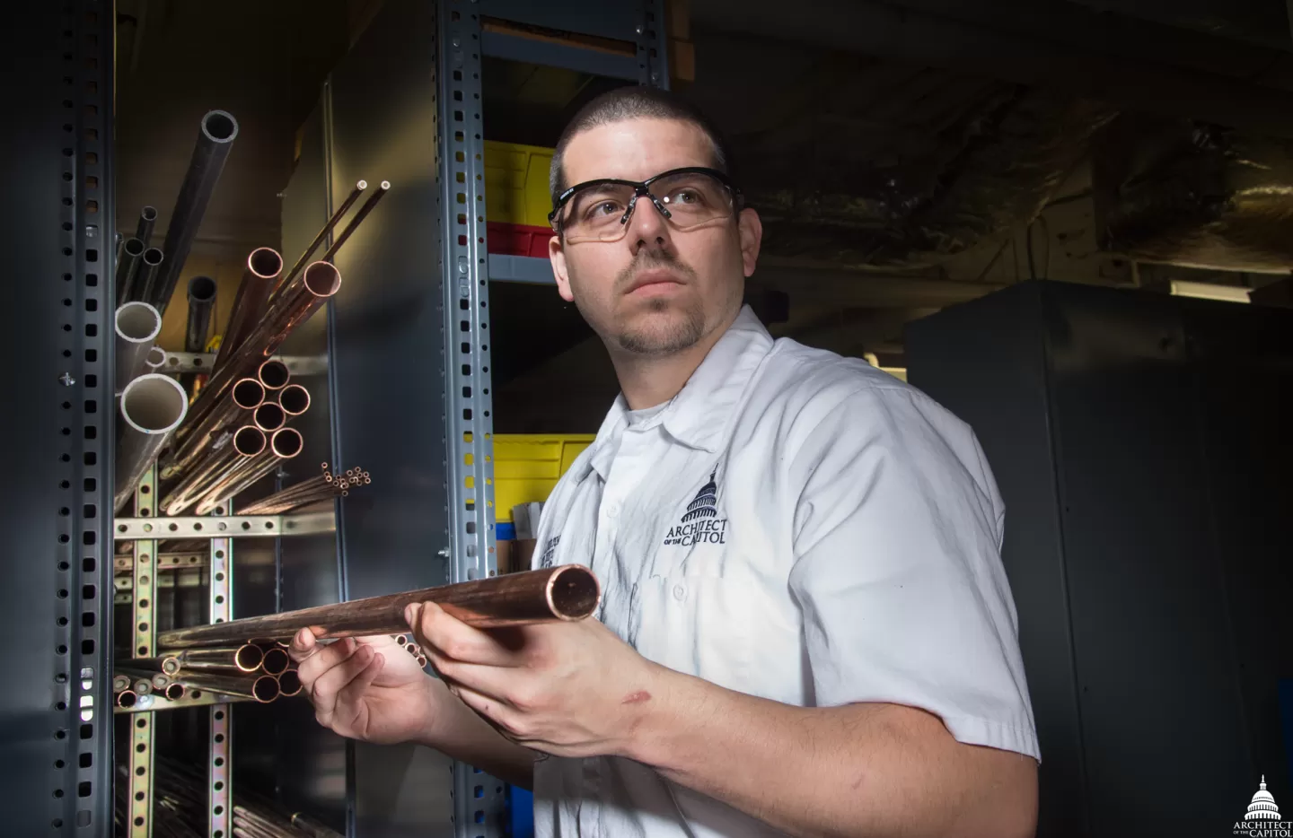 Person holding a copper pipe.