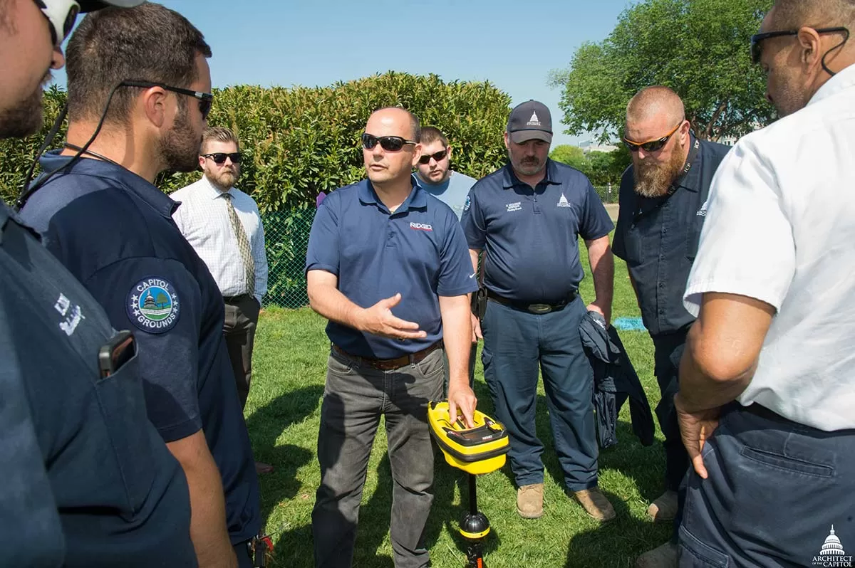 AOC employees test an underground utility locator on the West Front lawn of the U.S. Capitol.
