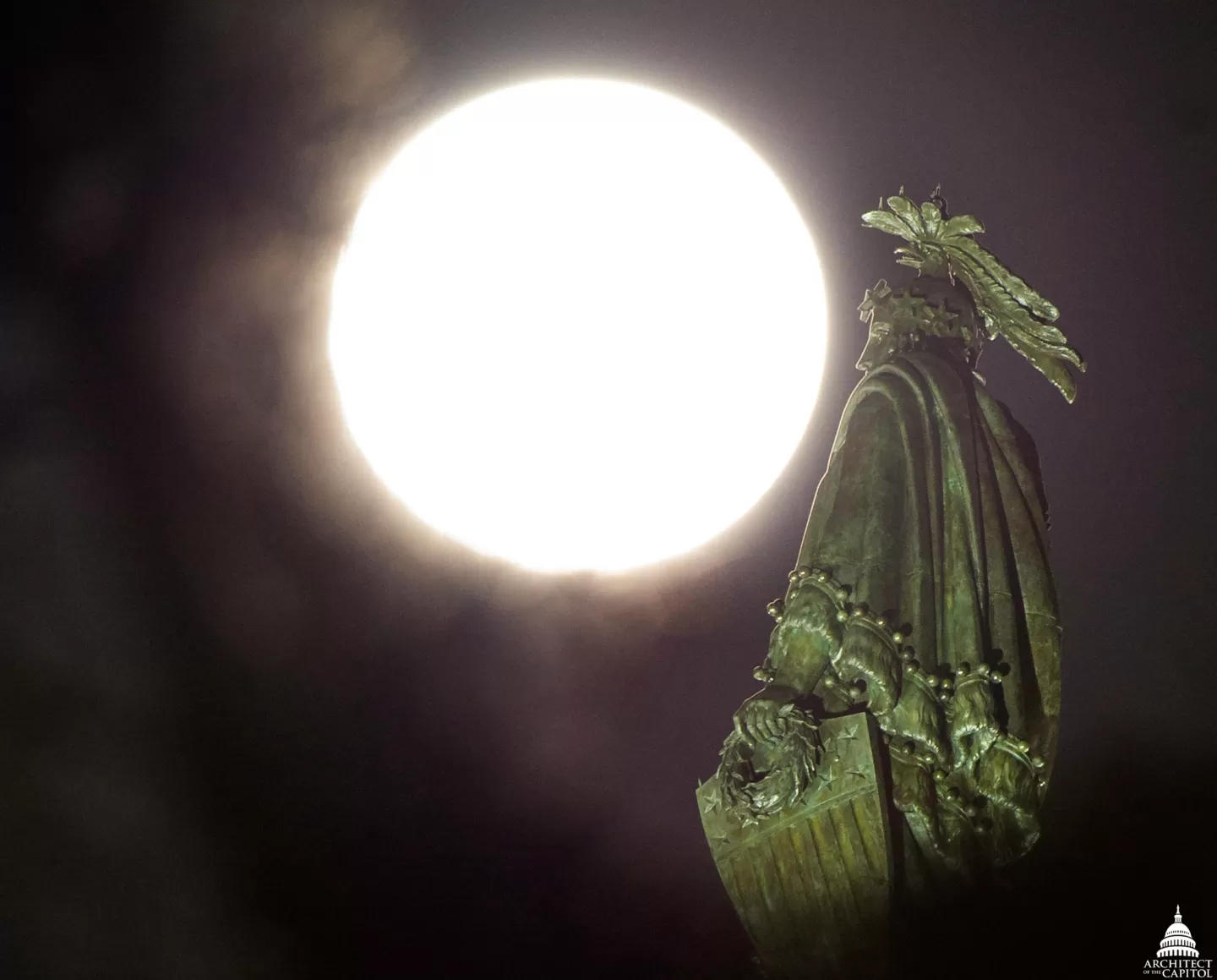 The moon and a statue of a person.