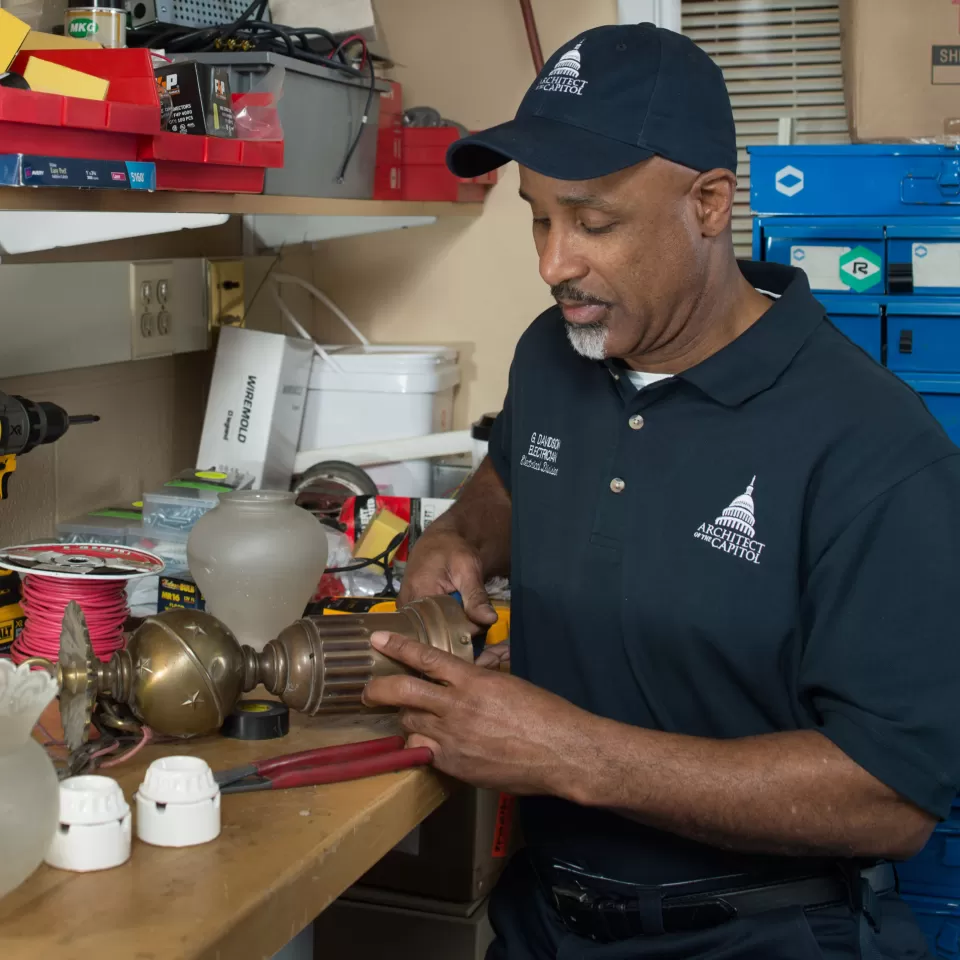 AOC employee fixing lamp