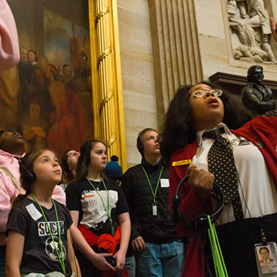 A visitor guide shows a tour group through the U.S. Capitol Rotunda.